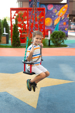 A boy bungee rides, swings, on a tightrope in a modern game park.の写真素材