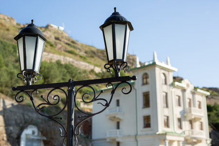 An old vintage lantern with glass on a column against the background of the mountain and the sky.の写真素材