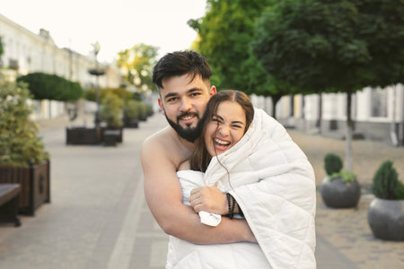 A couple in love, a man and a woman, hug and kiss on empty city streets at dawn in the morning.の写真素材