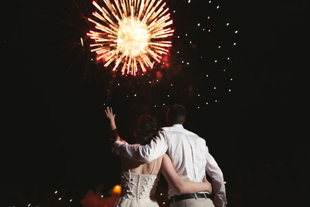 Newlyweds on the background of beautiful fireworksの写真素材