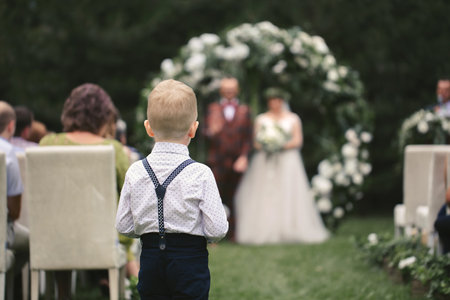 A little boy carries wedding rings for the bride and groomの写真素材