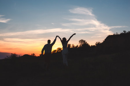 Loving couple together outdoor in mountains over scenic sunset sky background.の写真素材