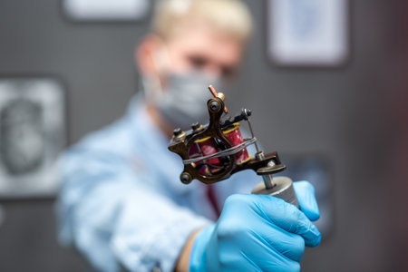 Tattoo machine close-up in the hands of a tattoo artist.の写真素材
