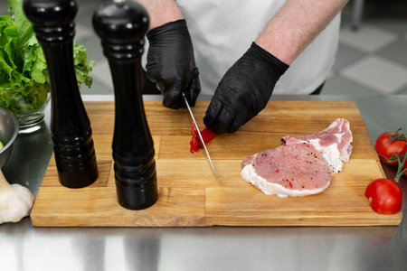 Chef man cutting chili peppers at table, closeup.の写真素材
