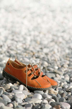 pair sandals on a pebbled beachの写真素材