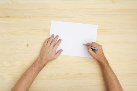 man writing on the paper, top view
