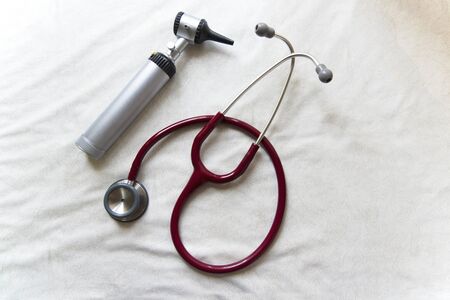 Otoscope and red stethoscope together white backgroundの写真素材
