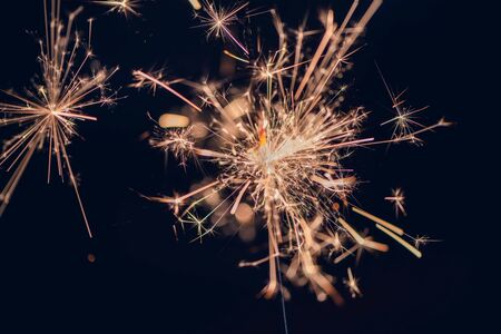 Single little sparkler in front of black background, close up, macro photographyの写真素材