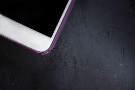 Smart phone on a black wooden background, close up, isolated