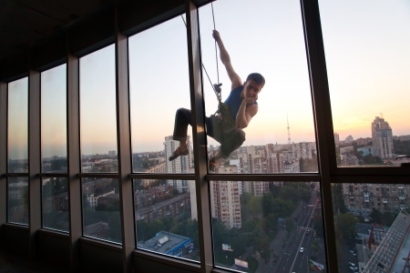 Industrial climber looking through a windowの写真素材