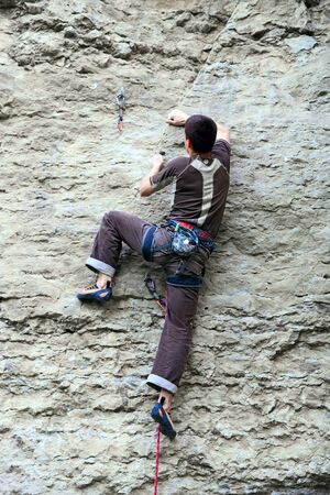 Rock climber climbing up a cliffの写真素材