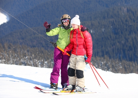 Young female skier and snowboarder on ski-lift の写真素材