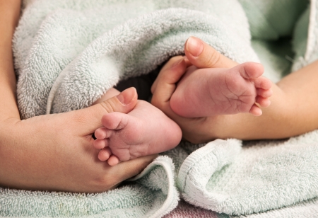 Mother holding newborn's feetの写真素材