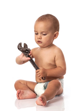 	Cute little boy holding an adjustable spanner over whiteの写真素材