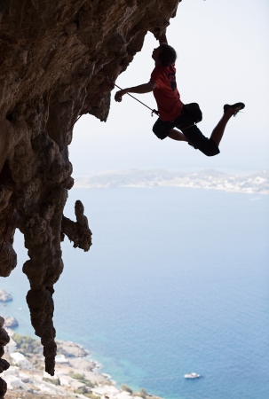Rock climber jumping on next handhold, Kalymnos Island, Greece の写真素材