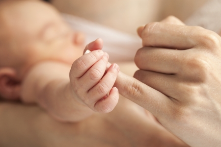Closeup view of newborn baby holding mother s handの写真素材