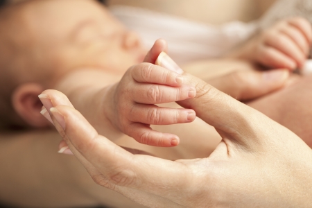Closeup view of newborn hand holding mother thumbの写真素材