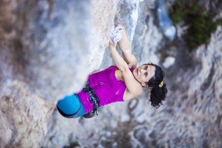 Young female rock climber on a cliff faceの写真素材