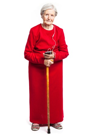 Senior woman listening to music over white backgroundの写真素材