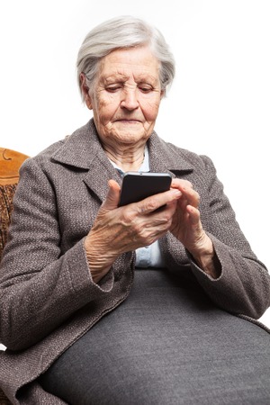 Senior woman using mobile phone on white backgroundの写真素材