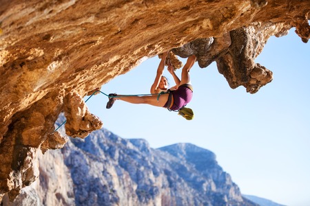 Young female rock climber on a cliff faceの写真素材