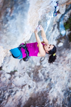 Young female rock climber on a cliff faceの写真素材