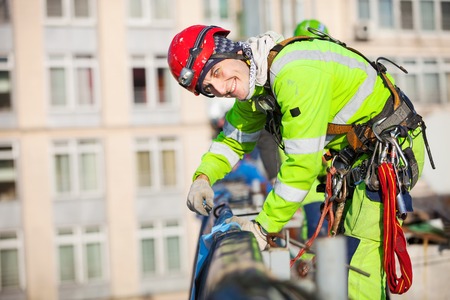 Young caucasian industrial climber on a roof of a building
