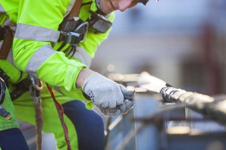 Closeup of industrial climber working on roof of buildingの写真素材