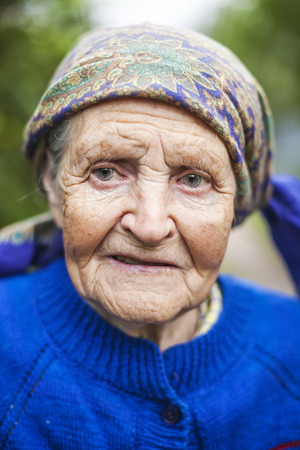 Portrait of an aged woman smiling outdoorsの写真素材