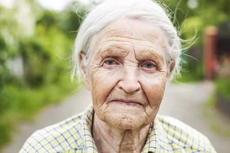 Portrait of an aged woman smiling outdoorsの写真素材