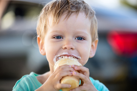 Cute little boy eating ice-cream and smilingの写真素材