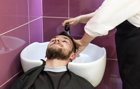 Young man having his hair washed in a hairdressing salonの写真素材