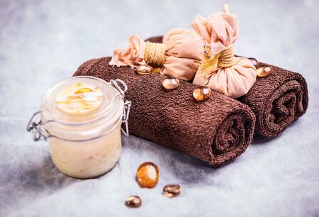 Spa treatment composition: container with body cream, towels, and decorative elementsの写真素材