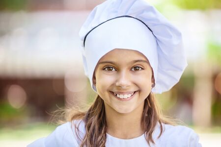 Smiling girl in a chef's hatの写真素材