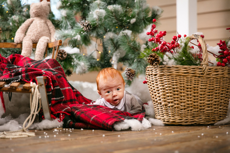 Cute baby boy lying on floor among Christmas decorations at homeの写真素材