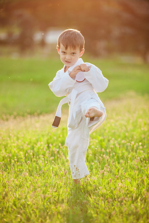 Preschool boy practicing karate outdoorsの写真素材