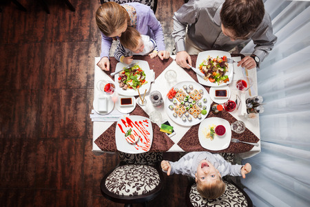 Family of four having meal at a restaurantの写真素材