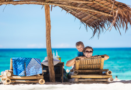 Cheerful mom and son enjoying beautiful day on the beachの写真素材