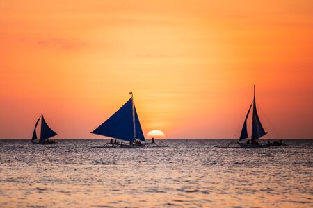 Sunset seascape with a sailboatの写真素材