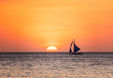 Sunset seascape with a sailboatの写真素材