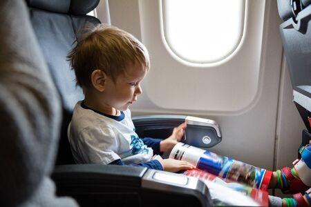 Little boy reading magazine on airplaneの写真素材