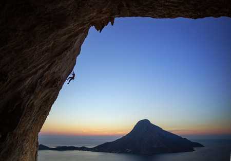 Rock climber on overhanging cliff at sunset. Kalymnos Island, Greece.の写真素材