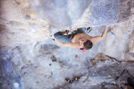 Male rock climber on a face of a cliff, view from above
