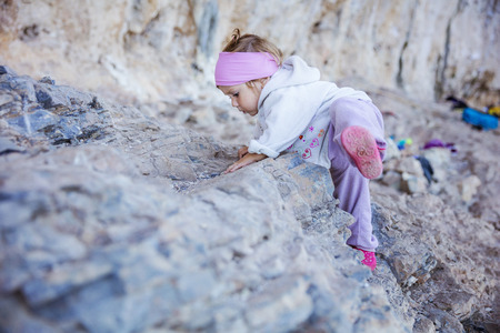 Little girl playing on rocks near climbing sectorの写真素材