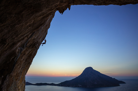 Rock climber on overhanging cliff at sunset. Kalymnos Island, Greece.の写真素材