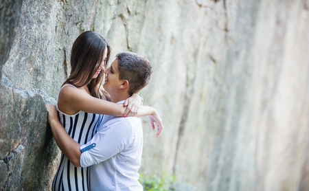 Romantic young couple going to kiss while standing at cliff on summer dayの写真素材