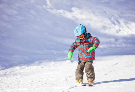 Little boy skiing downhill, learning  how to make turnsの写真素材