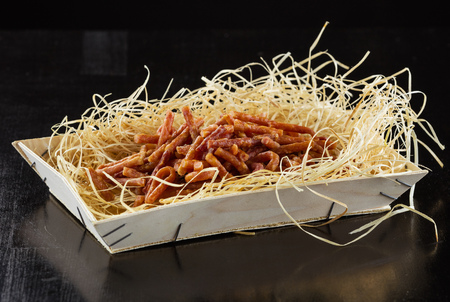 Mini salami picnic sausages in wooden box over black backgroundの写真素材