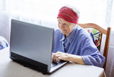 Senior woman using laptop computer at homeの写真素材