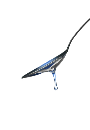 spoon with oil drop isolated on whiteの写真素材